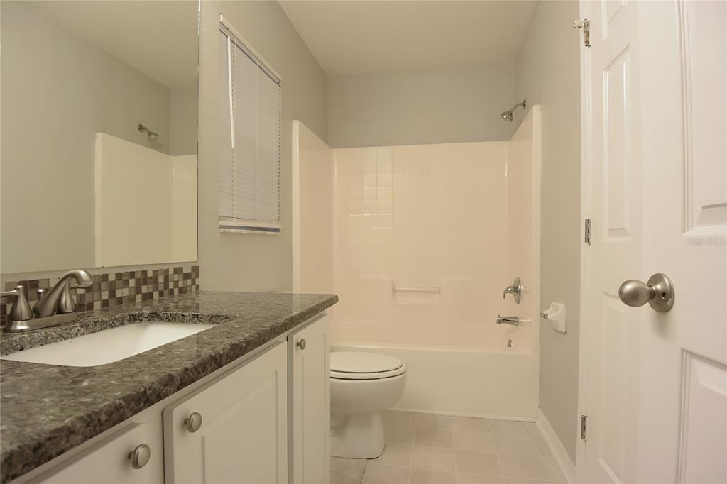 12042 Linden Drive Spring Hill, FL 34608 - Photo 29 of 41 a bathroom with a granite countertop sink a toilet and shower