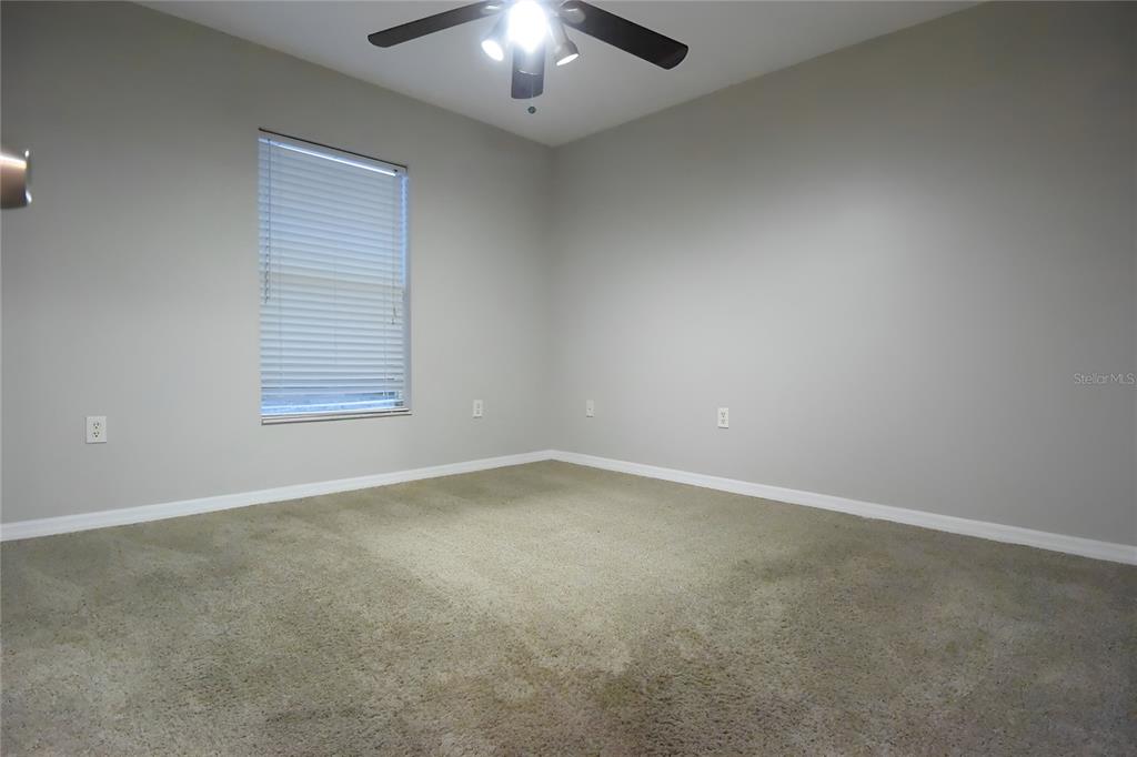 12042 Linden Drive Spring Hill, FL 34608 - Photo 32 of 41 an empty room with a chandelier fan and windows