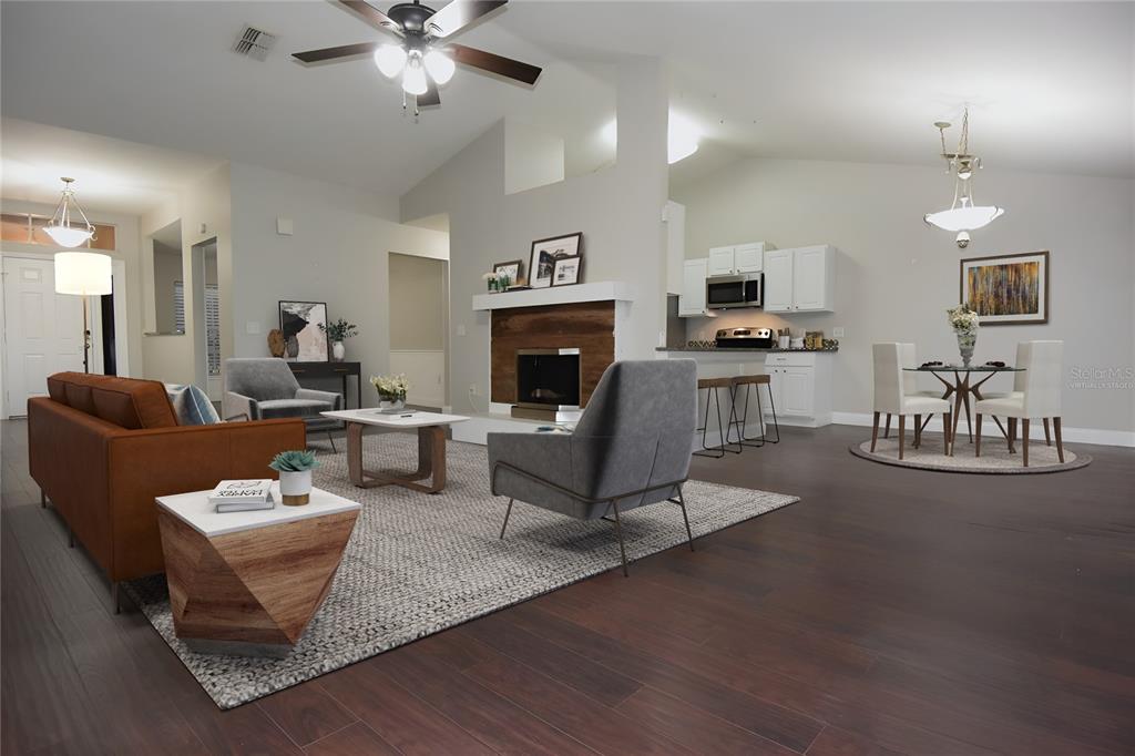12042 Linden Drive Spring Hill, FL 34608 - Photo 10 of 41 a living room with furniture a fireplace and a chandelier
