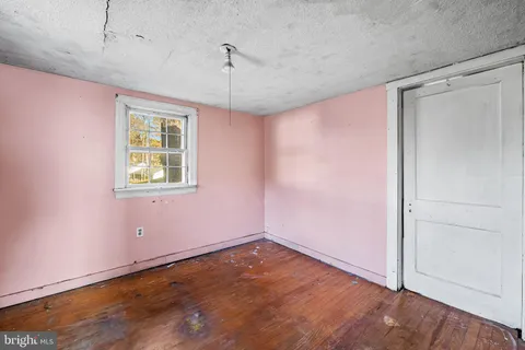 a room with a wooden floor and a window