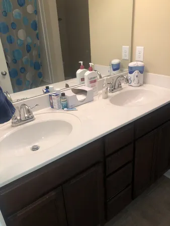 a bathroom with double vanity sinks and a mirror