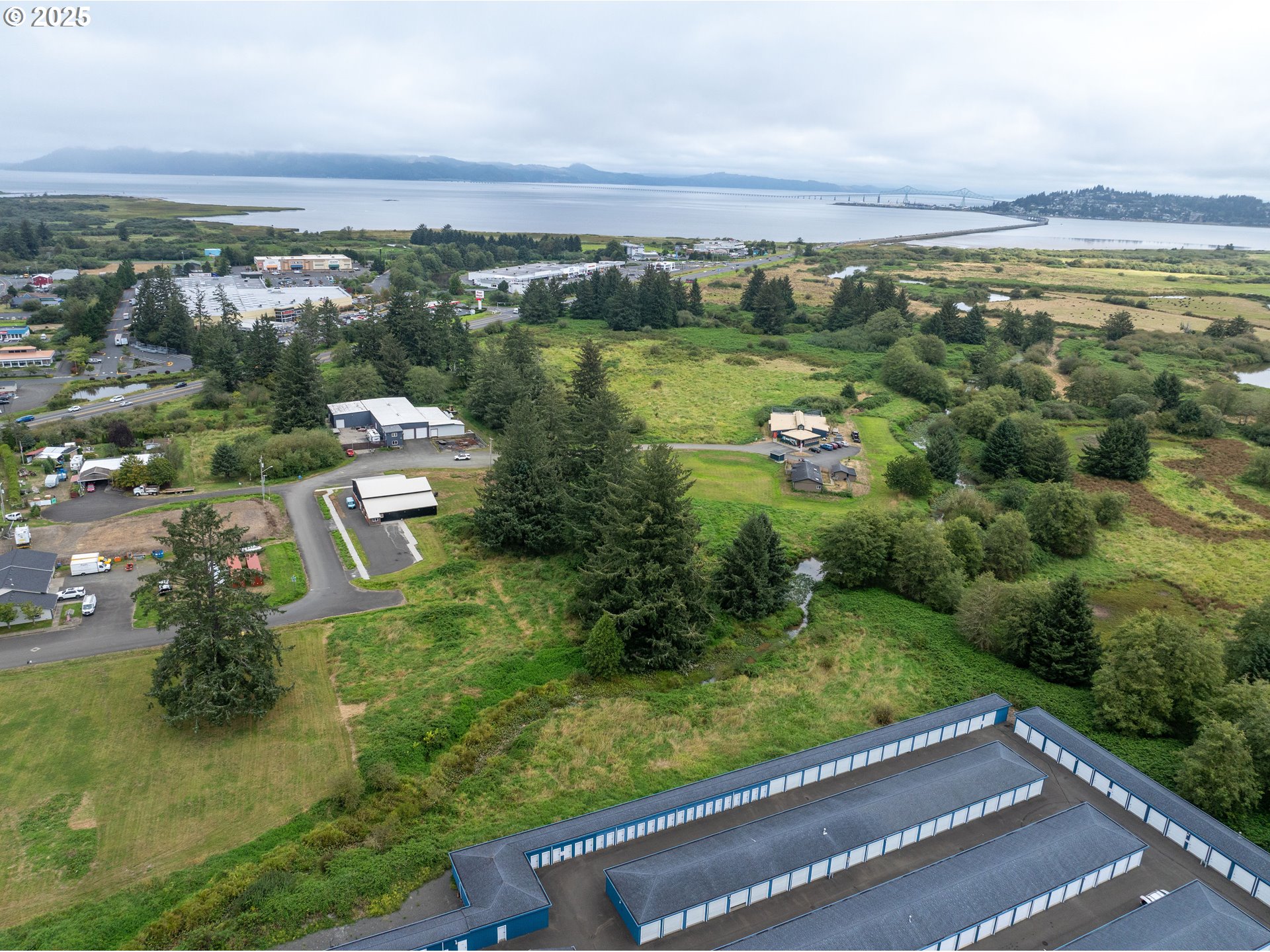 10 Southeast Se Street Warrenton, OR 97146 - Photo 2 of 8 an aerial view of green landscape with trees houses and lake view