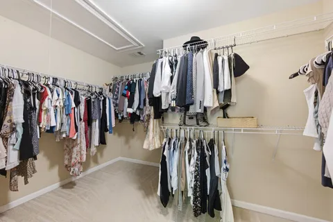 a view of walk in closet with clothes