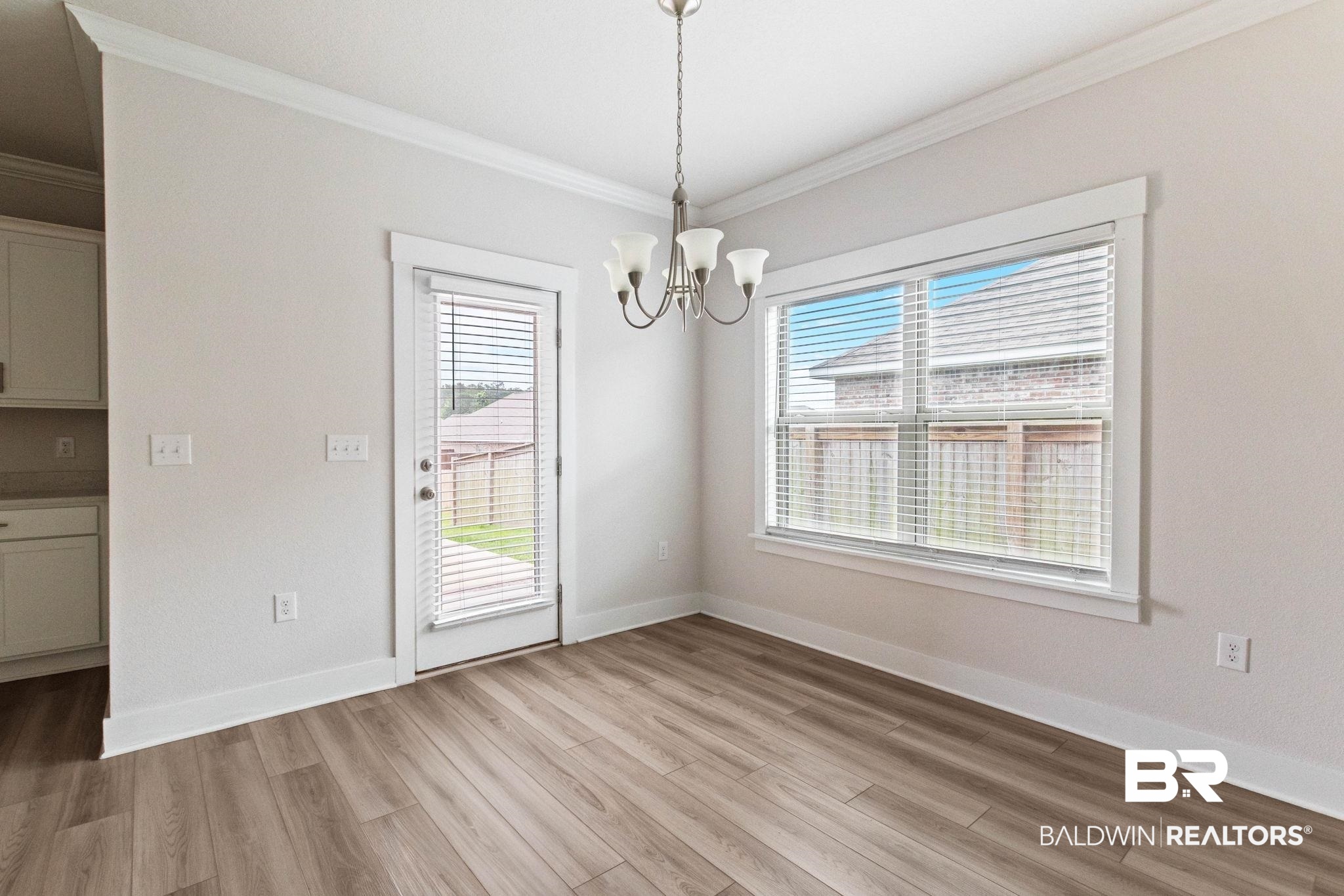 1710 Grouse Street Foley, AL 36535 - Photo 35 of 76 Dining area featuring wood-finish flooring, a contemporary chandelier, and ample natural light from a large window