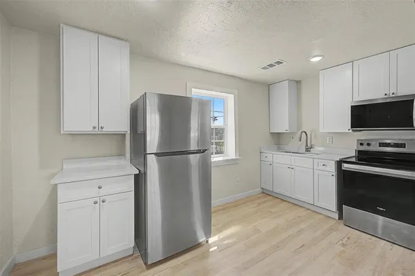 a kitchen with stainless steel appliances a stove a sink a stove and cabinets
