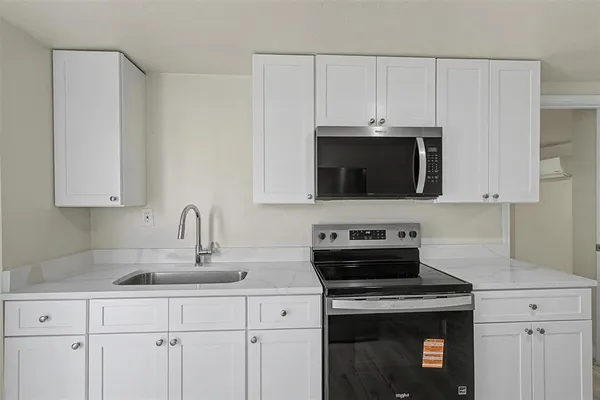 a view of a big room with wooden floor and windows