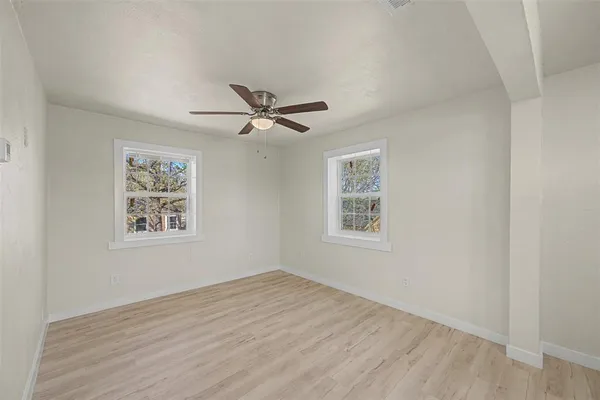 a view of a big room with wooden floor closet and fan
