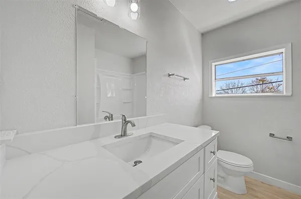 an empty room with wooden floor and ceiling fan