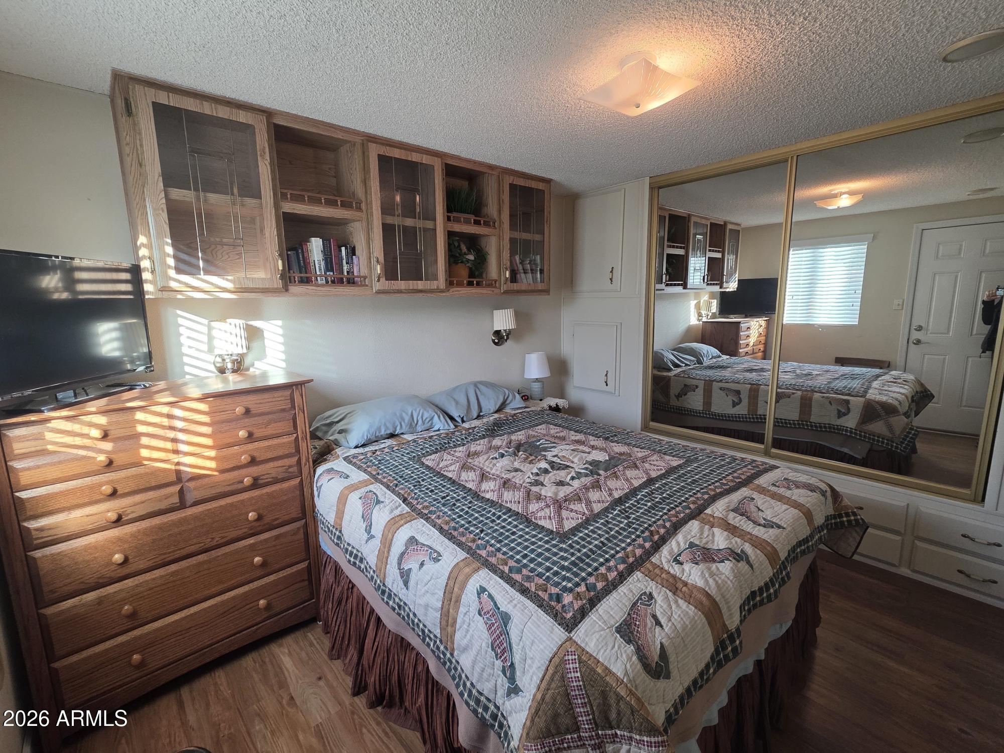 17200 West Bell Road, Unit 2169 Surprise, AZ 85374 - Photo 13 of 25 a bedroom with a bed and wooden floor