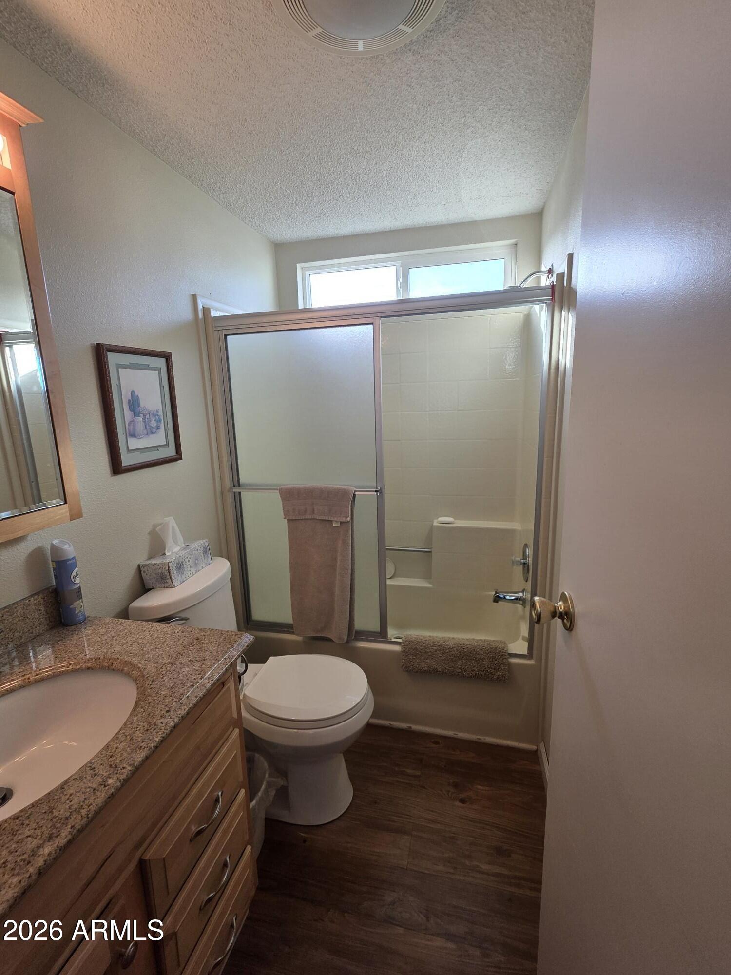 17200 West Bell Road, Unit 2169 Surprise, AZ 85374 - Photo 15 of 25 a bathroom with a granite countertop sink toilet a mirror and shower
