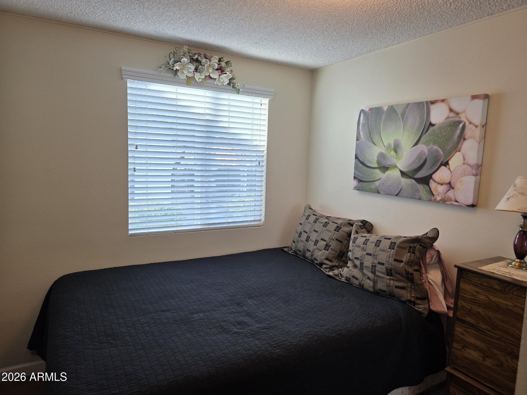 17200 West Bell Road, Unit 2169 Surprise, AZ 85374 - Photo 17 of 25 a bed sitting in a bedroom next to a window