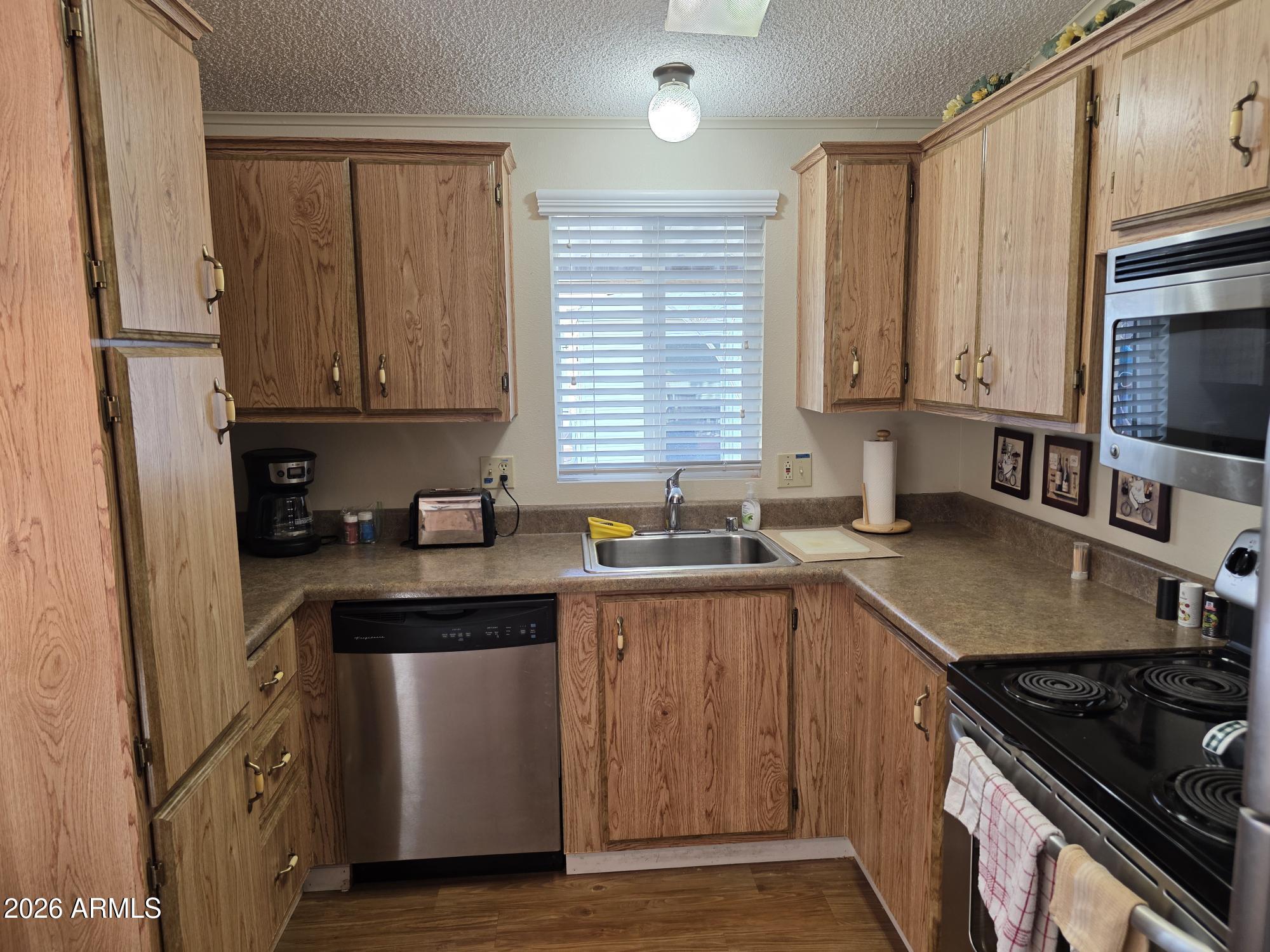17200 West Bell Road, Unit 2169 Surprise, AZ 85374 - Photo 7 of 25 a kitchen with stainless steel appliances granite countertop a sink stove and refrigerator