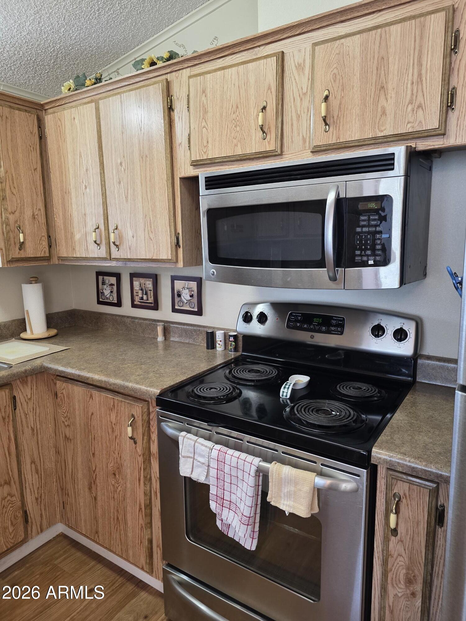 17200 West Bell Road, Unit 2169 Surprise, AZ 85374 - Photo 8 of 25 a kitchen with stainless steel appliances granite countertop a stove a sink and a microwave