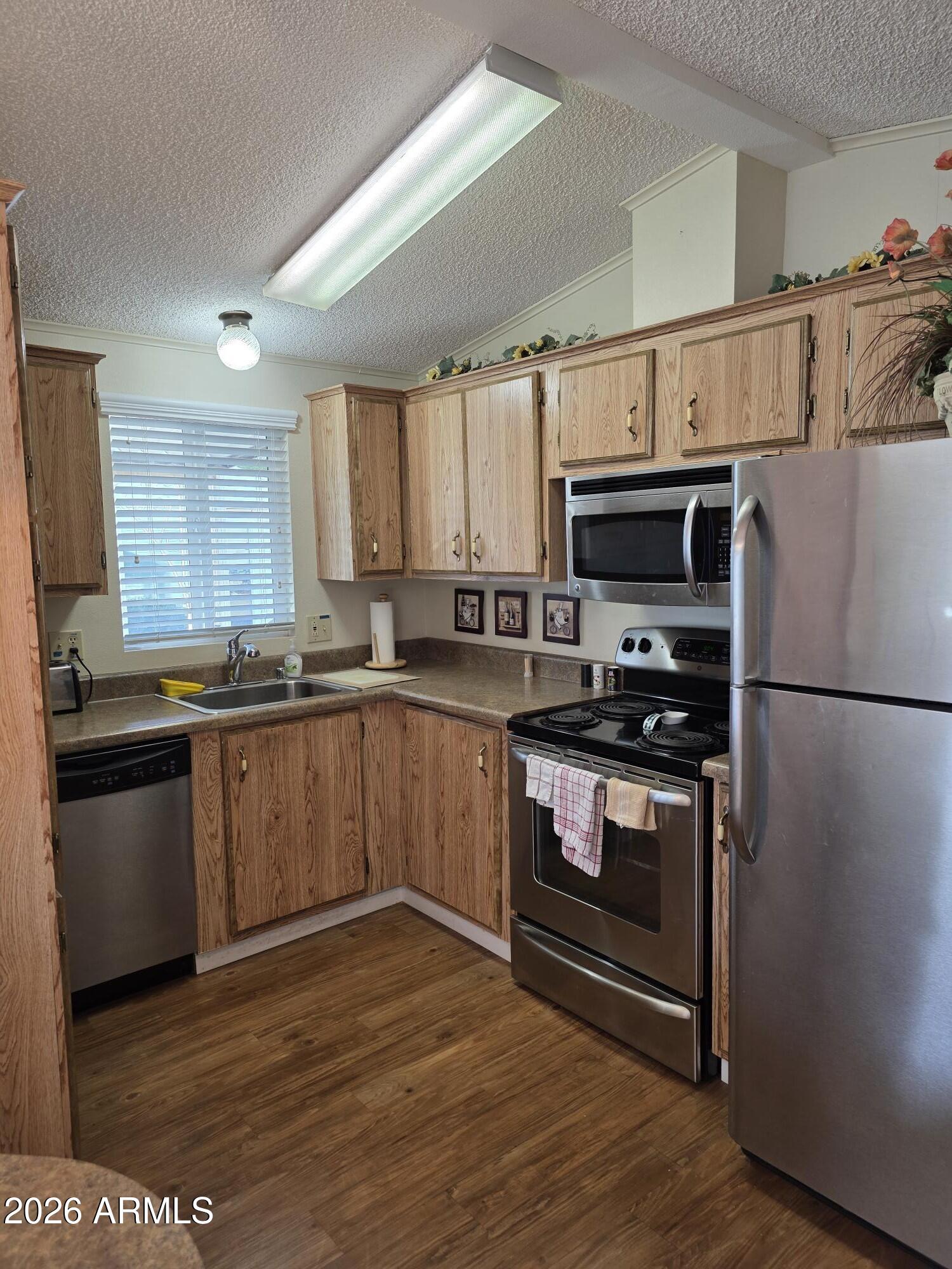 17200 West Bell Road, Unit 2169 Surprise, AZ 85374 - Photo 10 of 25 a kitchen with granite countertop a refrigerator and a stove top oven