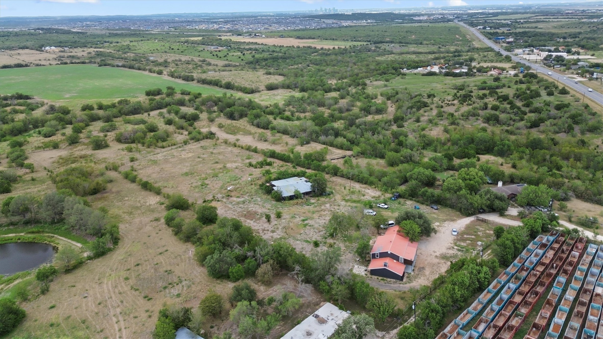 9100 Highway 183 Austin, TX 78747 - Photo 31 of 38 An expansive rural landscape features rolling hills, mature trees, and a private pond.