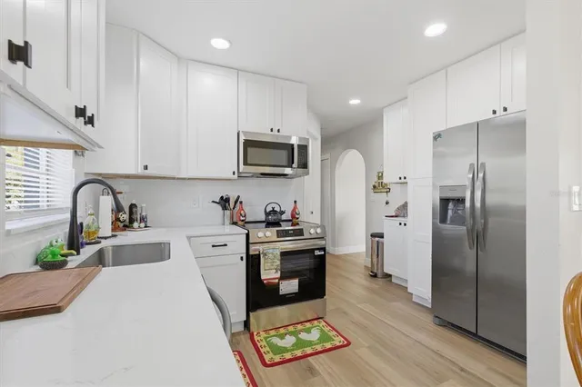 a kitchen with stainless steel appliances a refrigerator sink and microwave