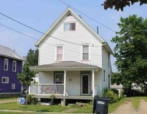 a front view of a house with a garden and plants