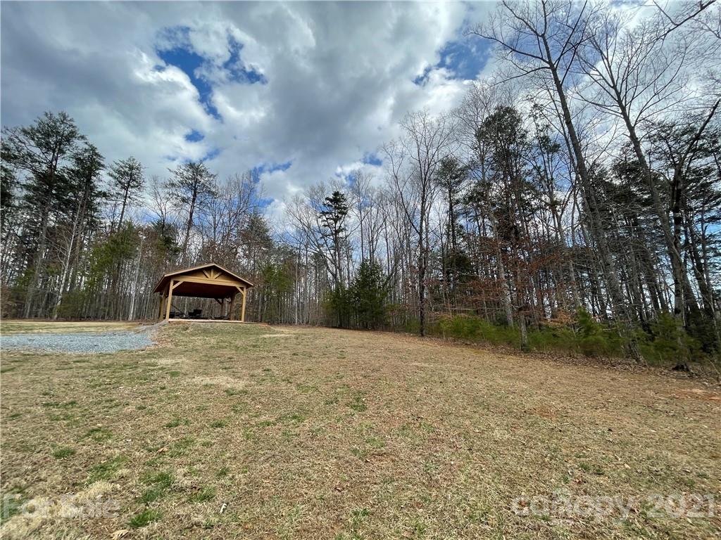 770 Padgett Road Union Mills, NC 28167 - Photo 26 of 48 a tall yellow house with a big yard and large trees