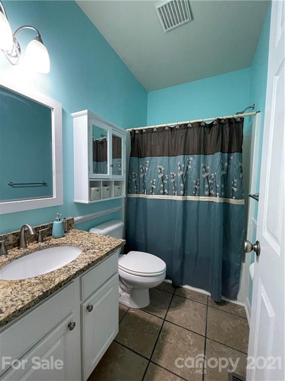 770 Padgett Road Union Mills, NC 28167 - Photo 38 of 48 a bathroom with a granite countertop sink a mirror and a toilet