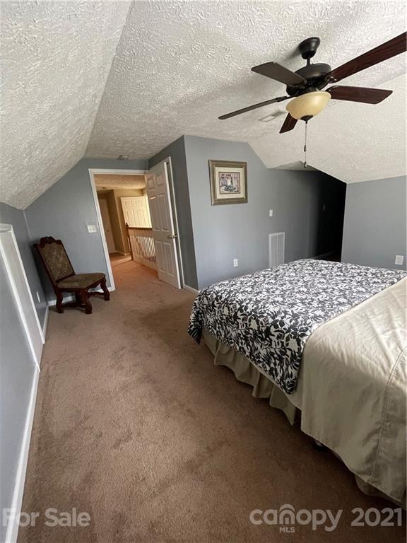 770 Padgett Road Union Mills, NC 28167 - Photo 44 of 48 a bedroom with a bed and a chandelier
