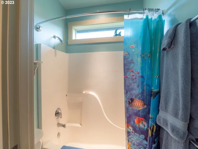 a living room with furniture a large window and stainless steel appliances