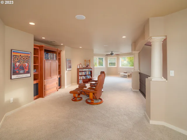 an empty room with windows and ceiling fan