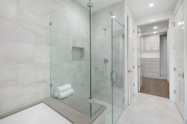 a view of a swimming pool with outdoor seating and a floor to ceiling window