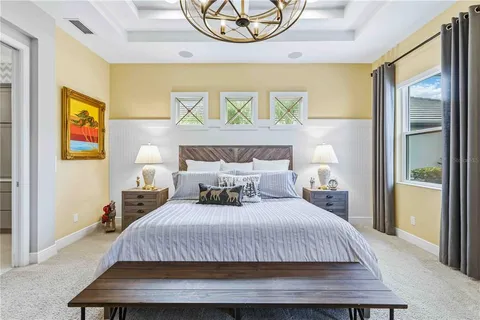 a bedroom with two beds and a chandelier