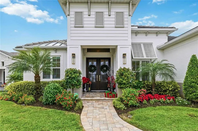 a view of a house with potted plants and a table and chair