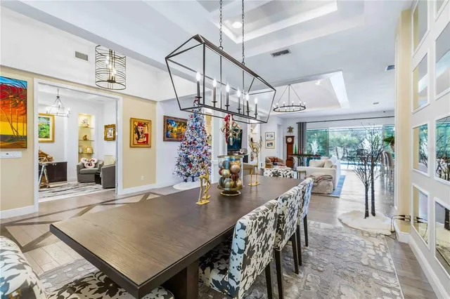 a living room with furniture kitchen view and a chandelier