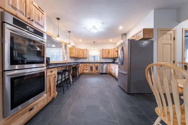 a kitchen with stainless steel appliances granite countertop a refrigerator a stove and a microwave