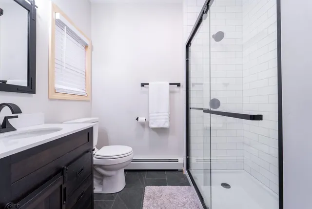 a bathroom with a granite countertop sink toilet and shower