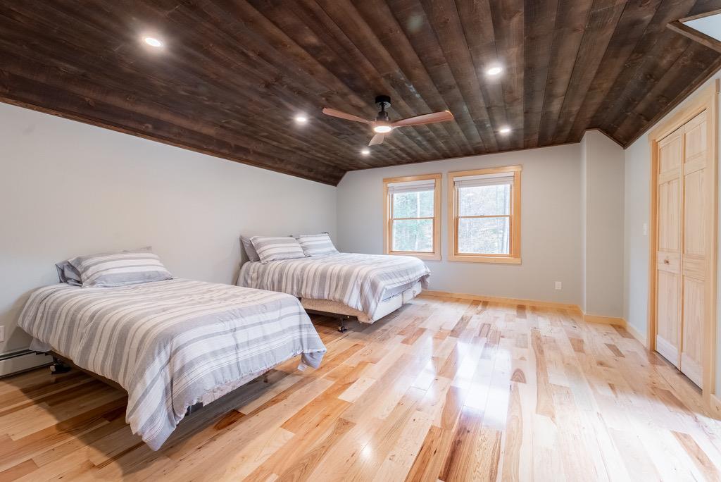 45 Campbell Mountain Road Downsville, NY 13755 - Photo 24 of 34 a spacious bedroom with two beds and a dresser with wooden floor