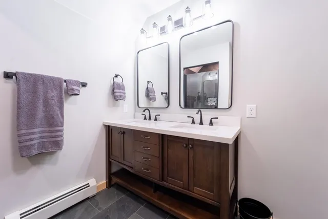 a bathroom with a double vanity sink and a mirror