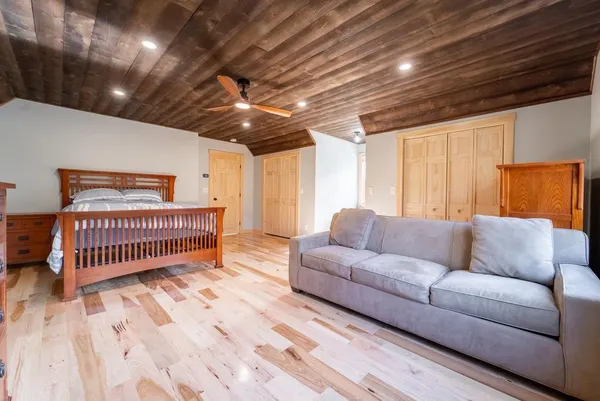 a bedroom with furniture and a wooden floor