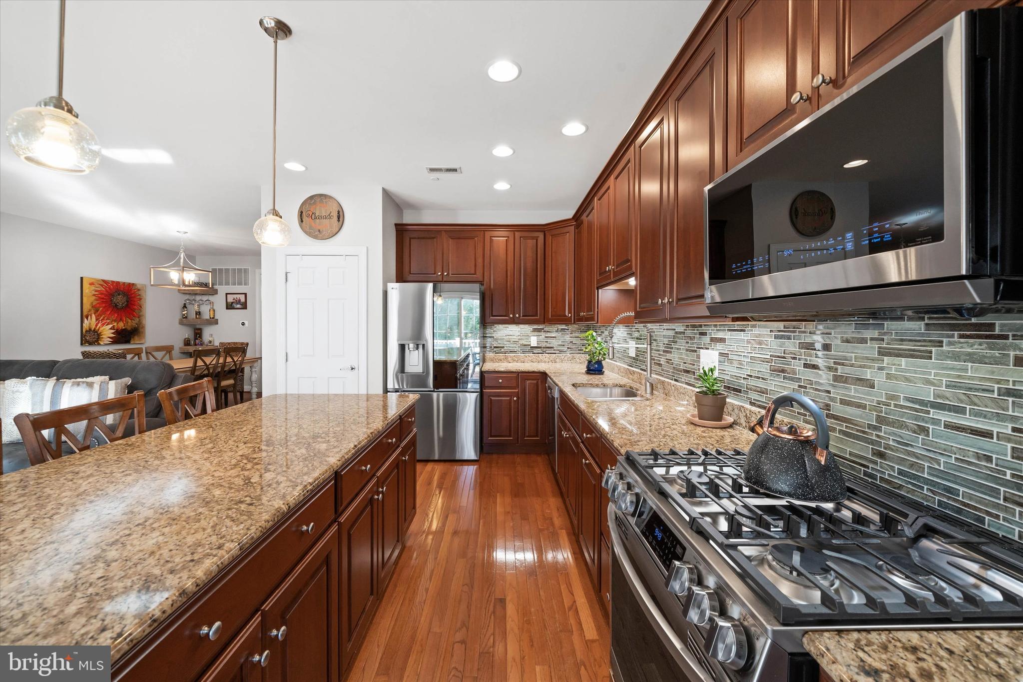 264 Deepdale Drive, Unit 31 Kennett Square, PA 19348 - Photo 6 of 34 a kitchen with stainless steel appliances granite countertop a stove a sink and a microwave
