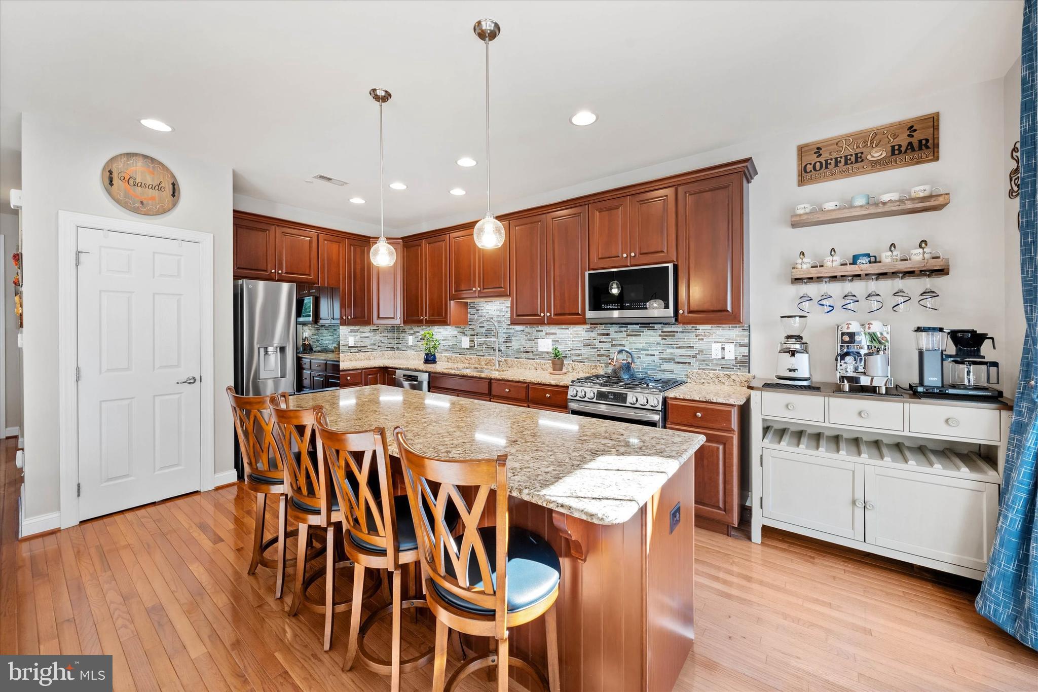 264 Deepdale Drive, Unit 31 Kennett Square, PA 19348 - Photo 10 of 34 a kitchen with stainless steel appliances granite countertop a stove top oven a sink a dining table and chairs with wooden floor