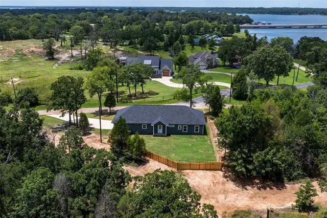 an aerial view of a house with a garden and lake view