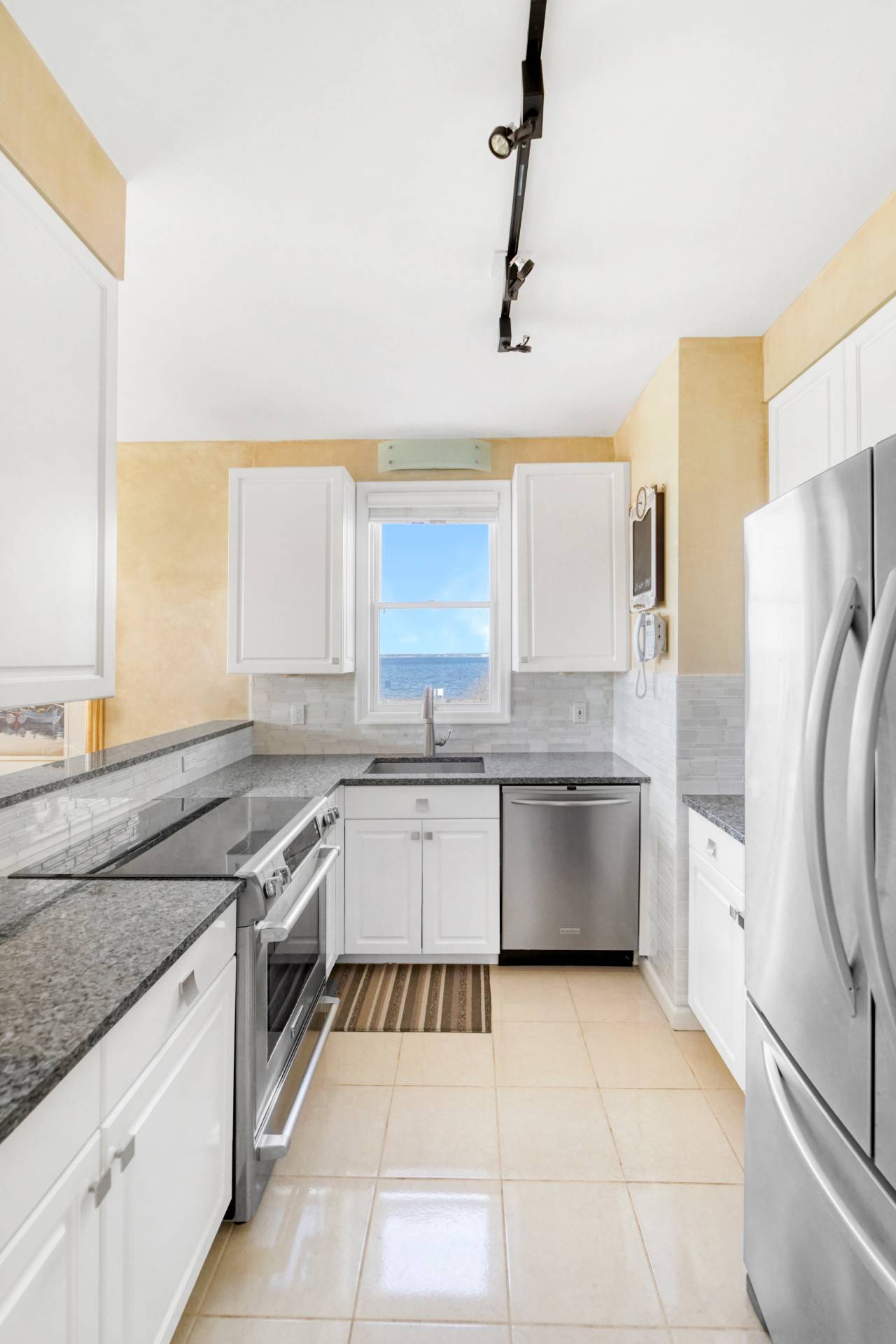 580 Dune Road, Unit 3 Westhampton Beach, NY 11978 - Photo 8 of 19 a kitchen with a stove a sink and a refrigerator