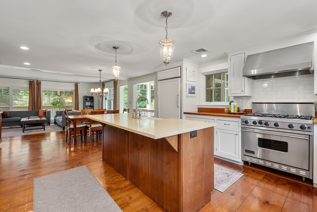 32 Intervale Road Weston, MA 02493 - Photo 5 of 42 a kitchen with a stove a sink a kitchen island with chairs and wooden floor