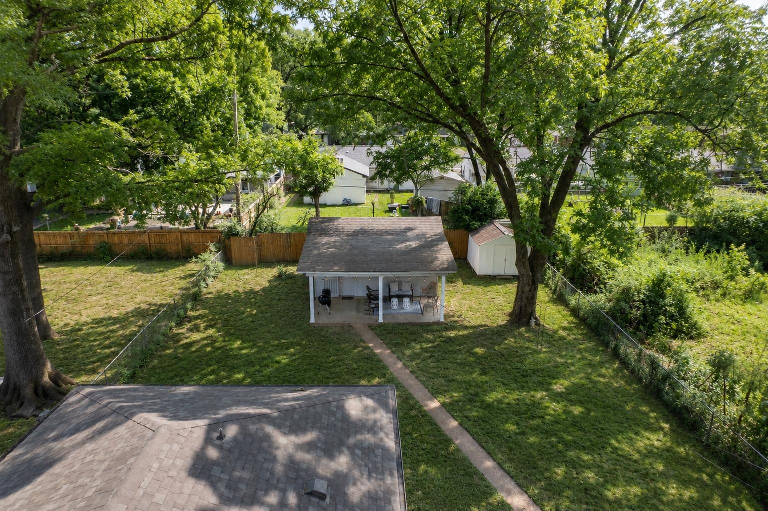 4491 Garnett Road Memphis, TN 38117 - Photo 27 of 32 Rear property featuring a covered patio, extensive grass area, mature trees, and a storage shed
