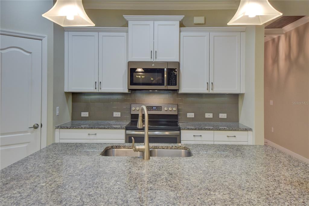 7408 Ridgelake Circle Bradenton, FL 34203 - Photo 12 of 39 a kitchen with granite countertop white cabinets and stainless steel appliances