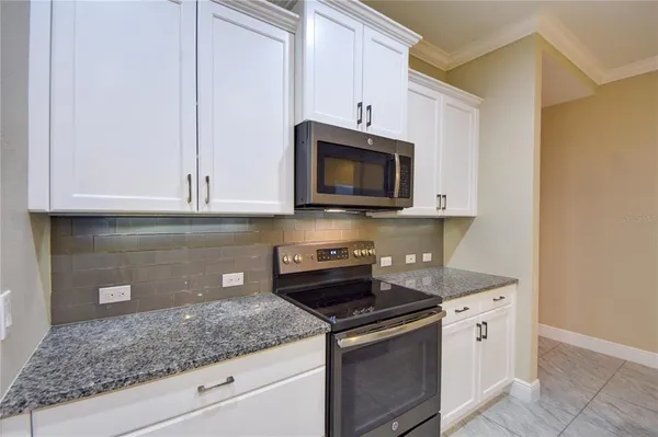 a kitchen with stainless steel appliances granite countertop a sink a stove and microwave