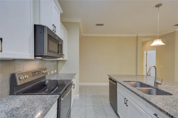 a kitchen with stainless steel appliances granite countertop a sink stove and microwave