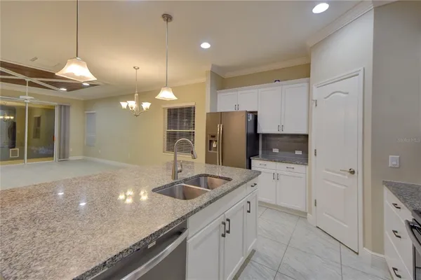 a kitchen with stainless steel appliances granite countertop a sink and refrigerator