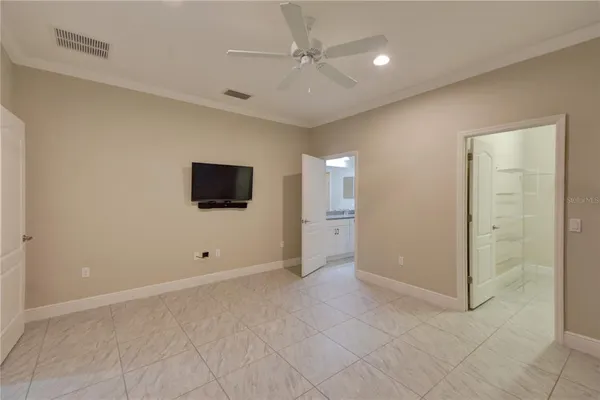 an empty room with windows and fan