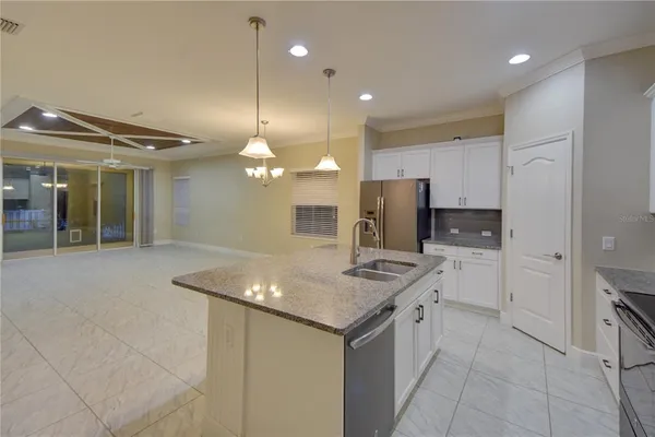 a kitchen with stainless steel appliances granite countertop a sink and a refrigerator