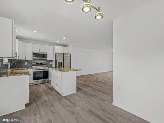 a kitchen with a refrigerator a stove top oven and kitchen island