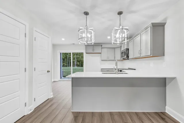 a view of living room with wooden floor and chandelier