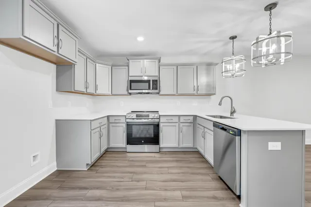 a kitchen with kitchen island granite countertop a sink cabinets and stainless steel appliances
